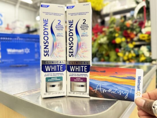 person holding walmart gift card in front of two boxes of Sensodyne Toothpaste