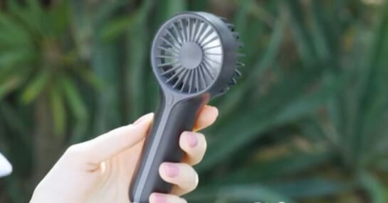 A hand holding a Mini Personal Fan Handheld