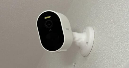 white Tenvis security camera on an upper wall in a home